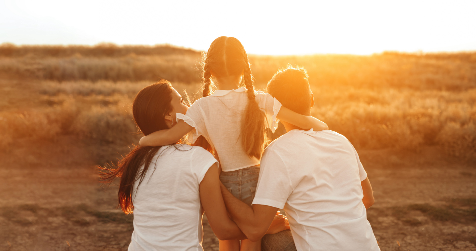 Two adults and child watching the sunset