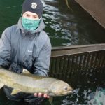 Photo of two employees working in a fish hatchery