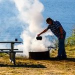 A camper douses a campfire.