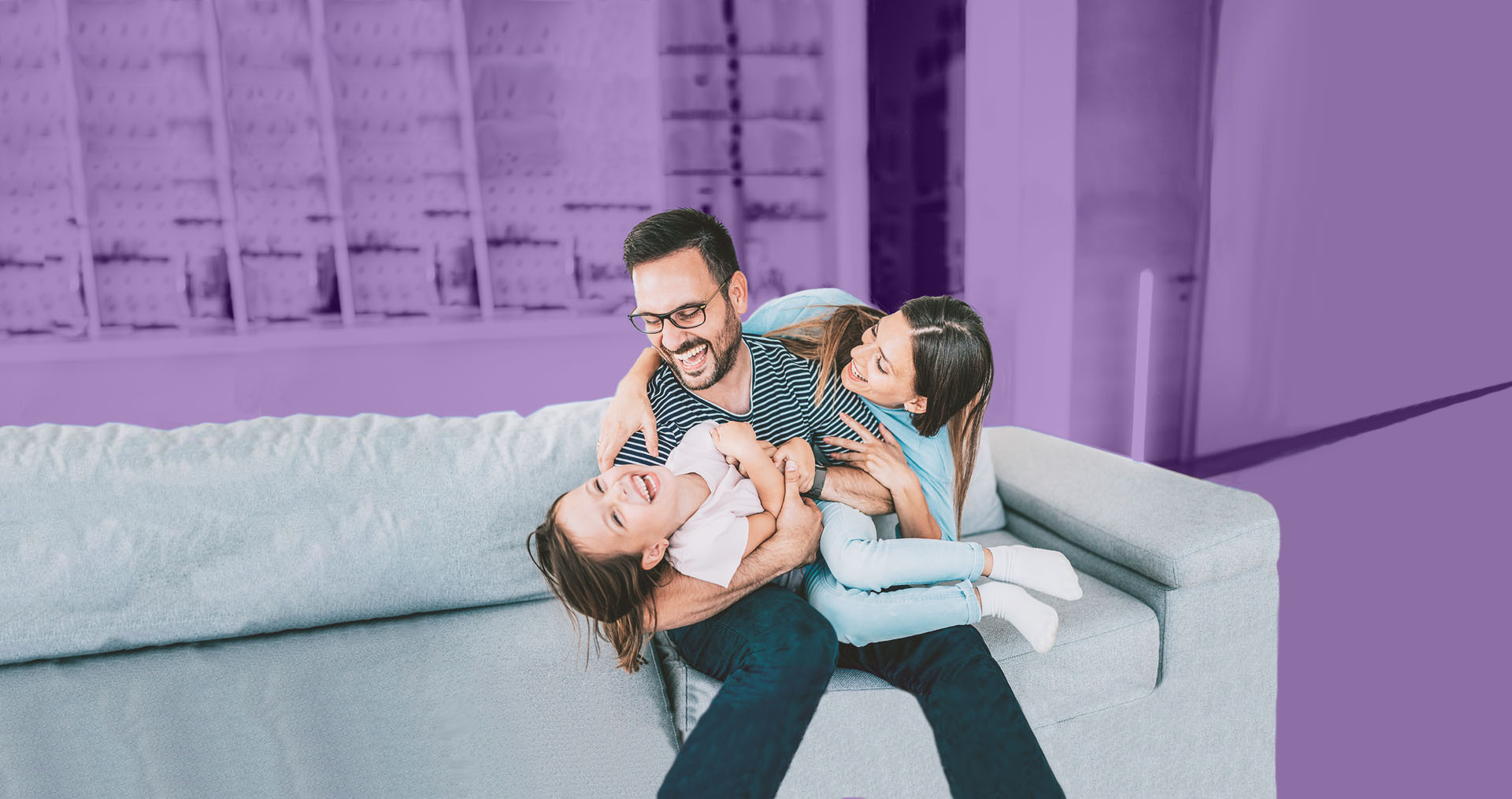 Image of a family laughing and sitting on a couch