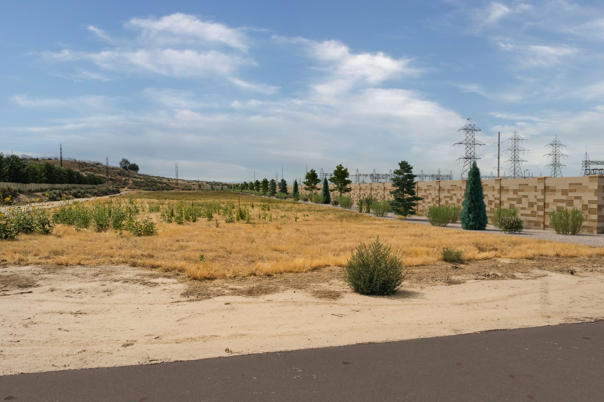 A simulated view of the wall and landscaping that would surround the proposed Boise Bench Substation batteries, looking west from Holcomb Road.