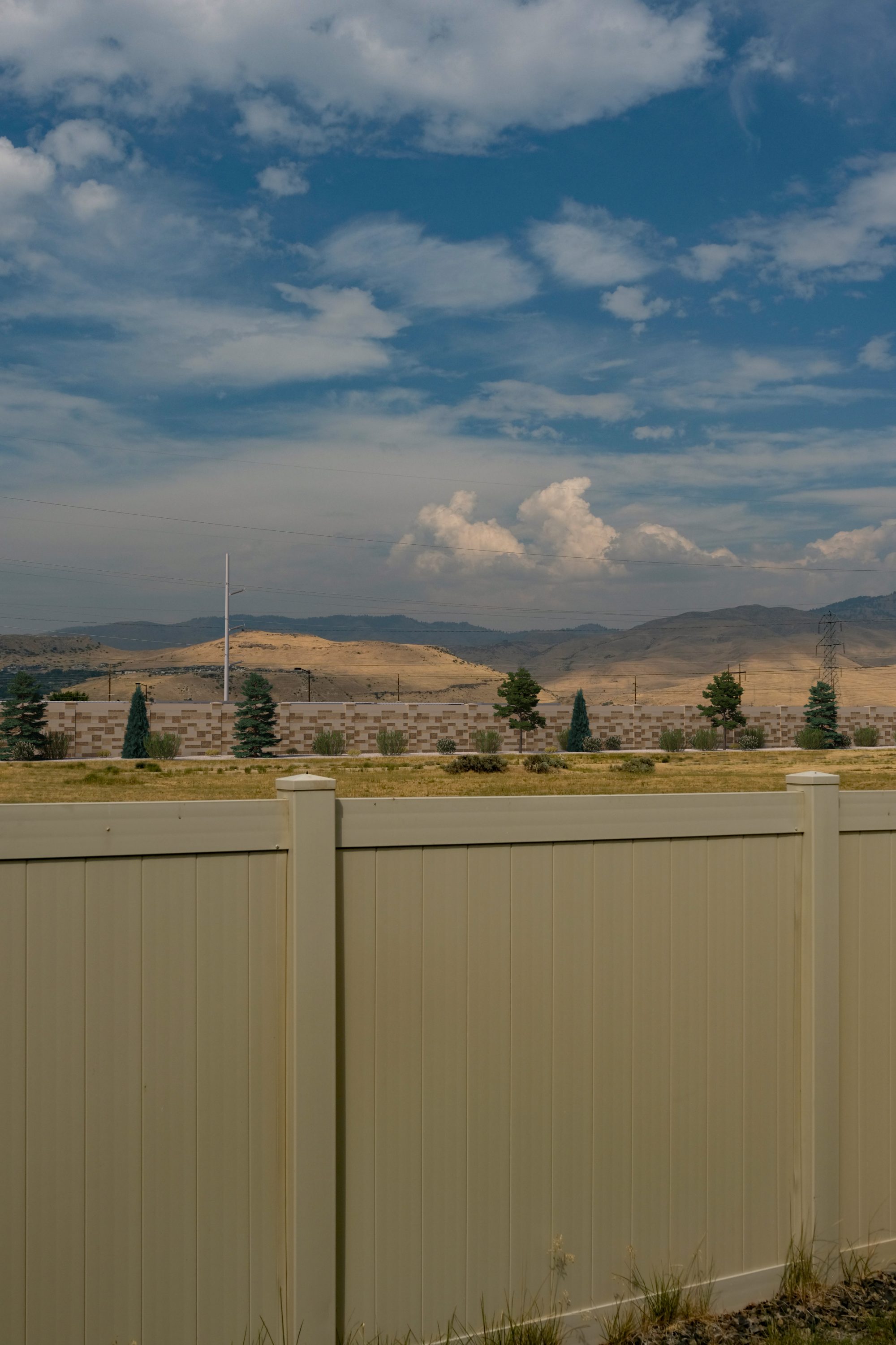 A simulated view of the concrete wall and landscaping that would surround the Boise Bench Substation batteries, looking north from the backyard of a nearby home.