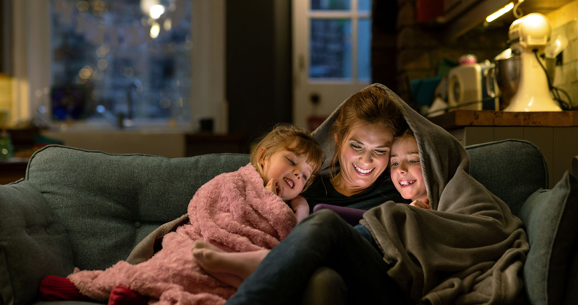 Mom with kids cuddled on the couch