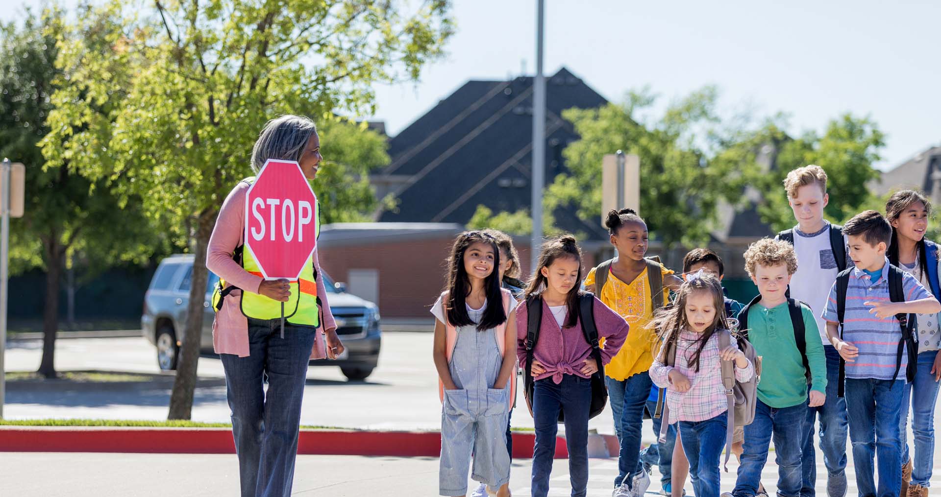 Young kids crossing a road safely to go to school.