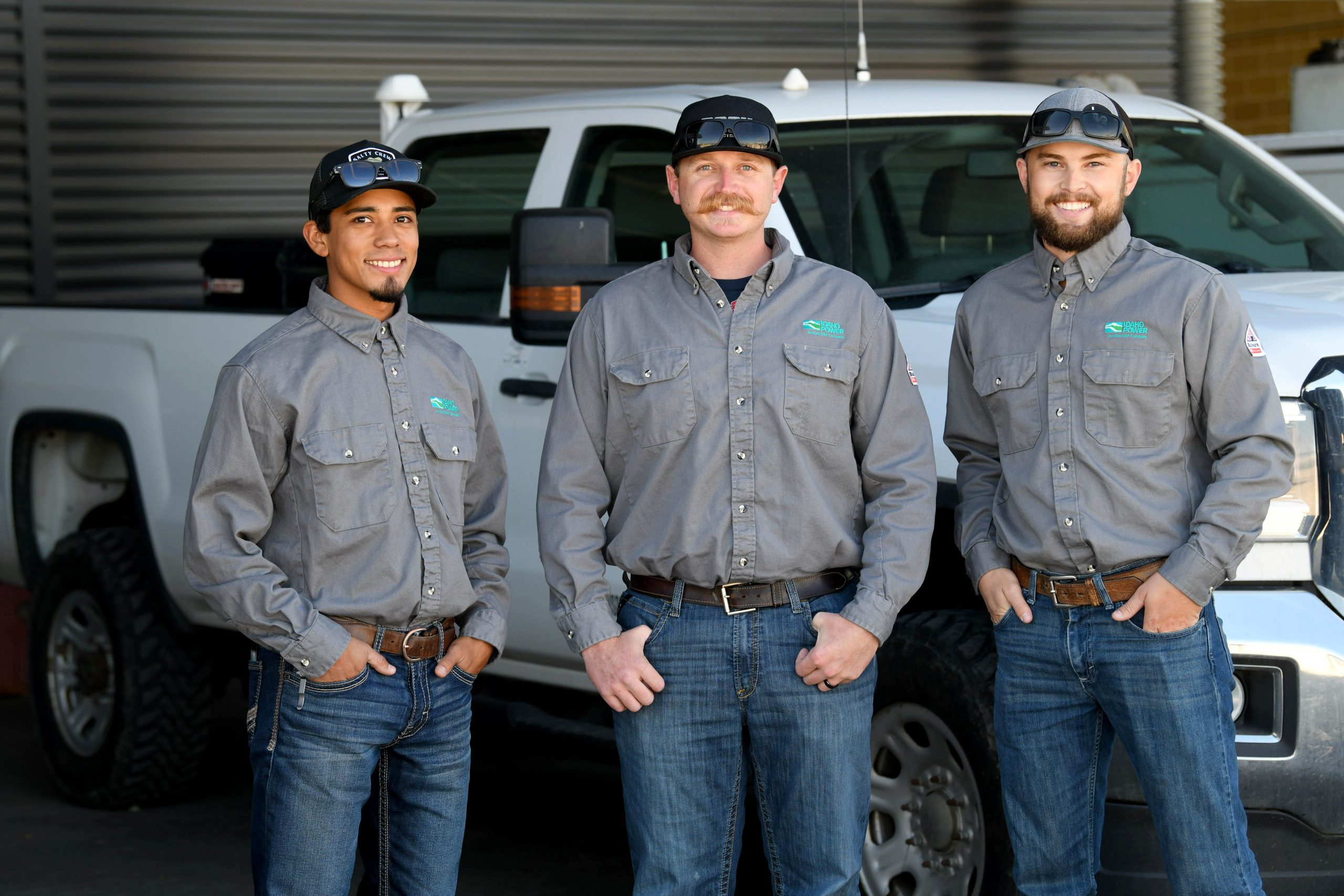 Three male apprenticeship graduates standing together and smiling