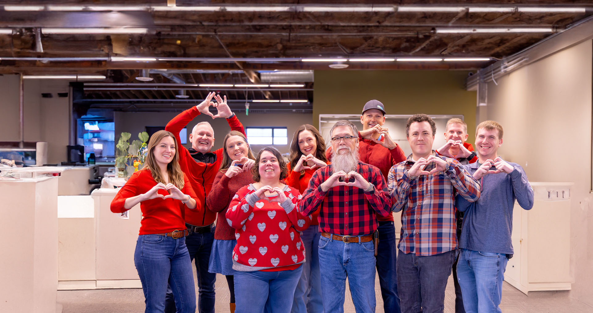 Idaho Power employees standing together, wearing red, and holding heart hands