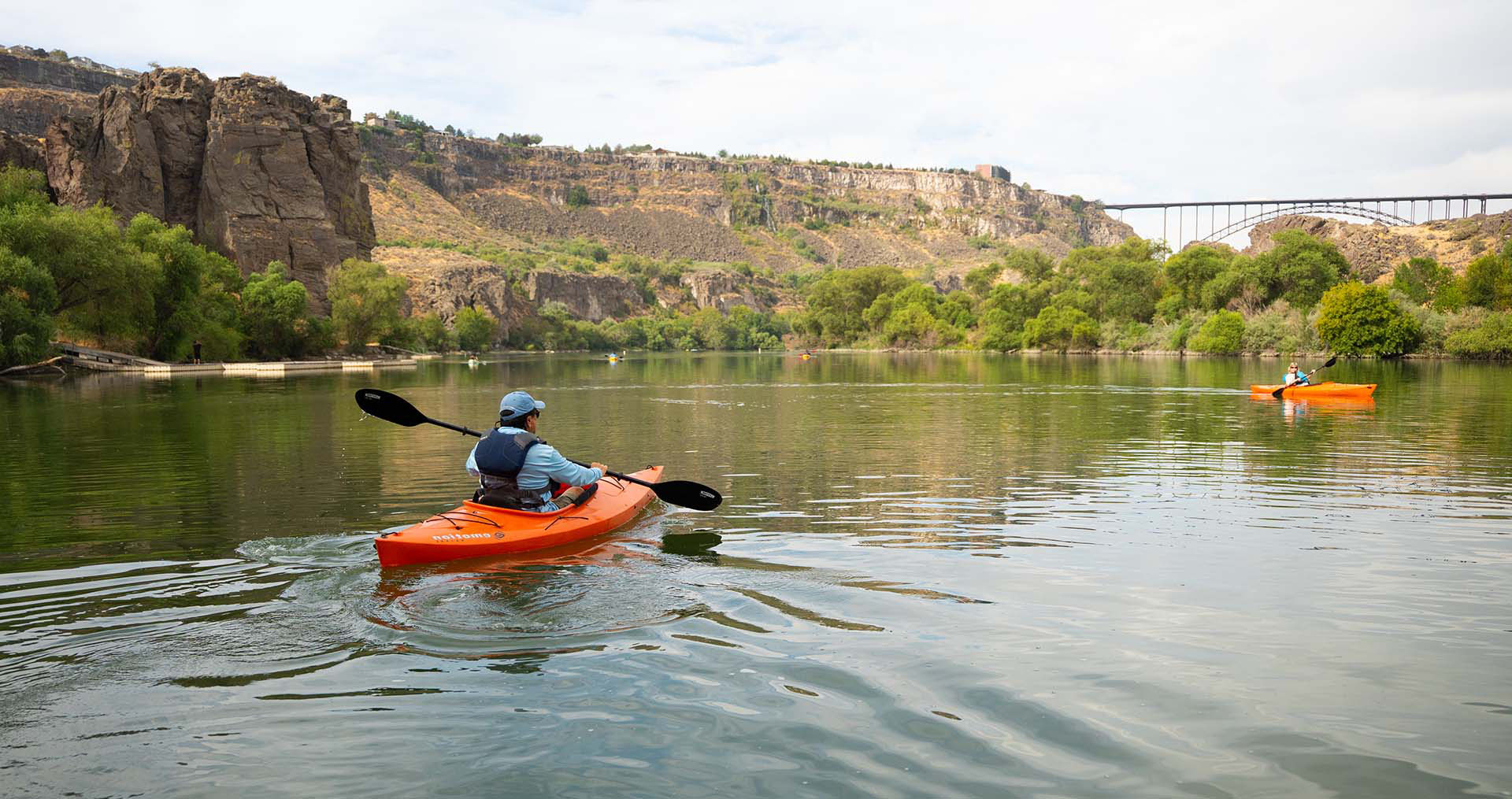 Man and women in kayaks floating on a river